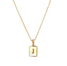 Load image into Gallery viewer, Gold initial necklace with the letter “J” on a mother of pearl pendant, hanging from a dainty gold chain, displayed on a white background.